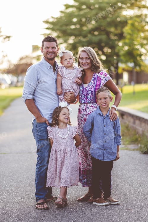 Preview: Vertical shot of an adorable happy family in a park