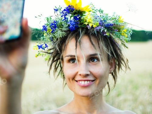 Preview: A girl in a wreath takes a selfie in a Ukrainian field