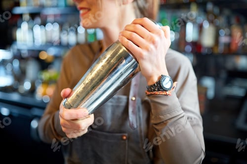 Preview: close up of bartender with cocktail shaker at bar