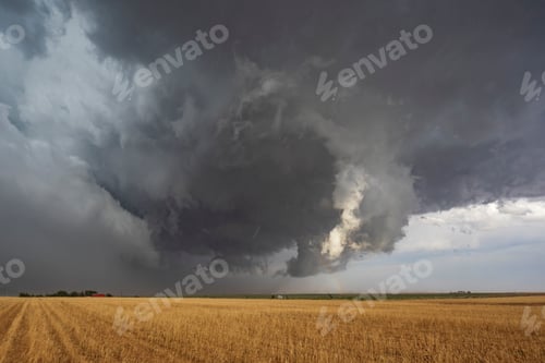 Preview: The back side of a Tornado-Warned Supercell, clouds on the horizon over farmland.