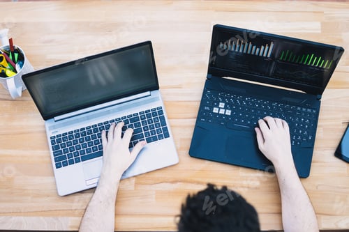 Preview: Man trading cryptocurrencies using two laptops