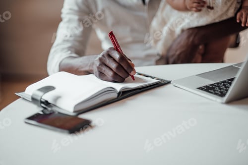 Preview: Black ethnicity man enjoys distance work sitting in a cozy loft apartment with todlerkid