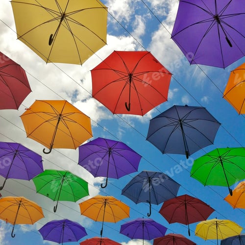 Colorful Umbrellas Against Cloudy Blue Sky