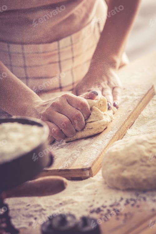 Preview: Close up of female baker hands kneading dough.