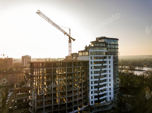 Preview: Apartment or office tall building under construction, top view. Tower crane and city landscape