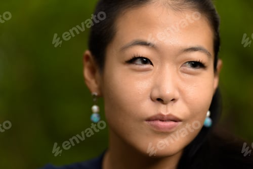 Preview: Close-up portrait of beautiful rebel Asian woman face smiling and thinking outdoors