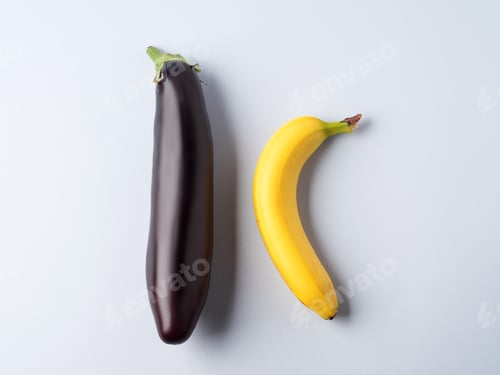 Preview: Eggplant and banana on gray background. Couple concept