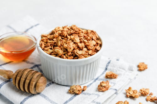Preview: Delicious Granola with Honey on a White Tablecloth