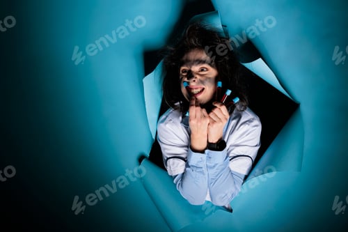 Preview: Mad scientist with messy hairstyle and filled glass test tubes grinning dreadful at camera while on
