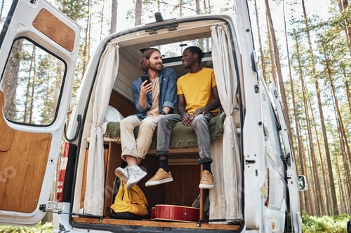 Preview: Friends sitting in van during camping
