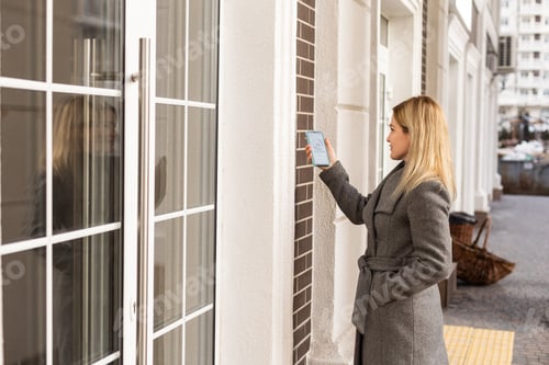 Preview: Woman hands using phone scan to digital door lock security systems at home
