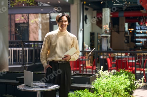 Vista previa: Japanese man wearing stylish sweater holding digital tablet and looking at camera