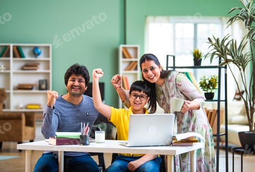 Preview: Indian Asian parents sitting beside successful son studying on laptop, supporting education at home