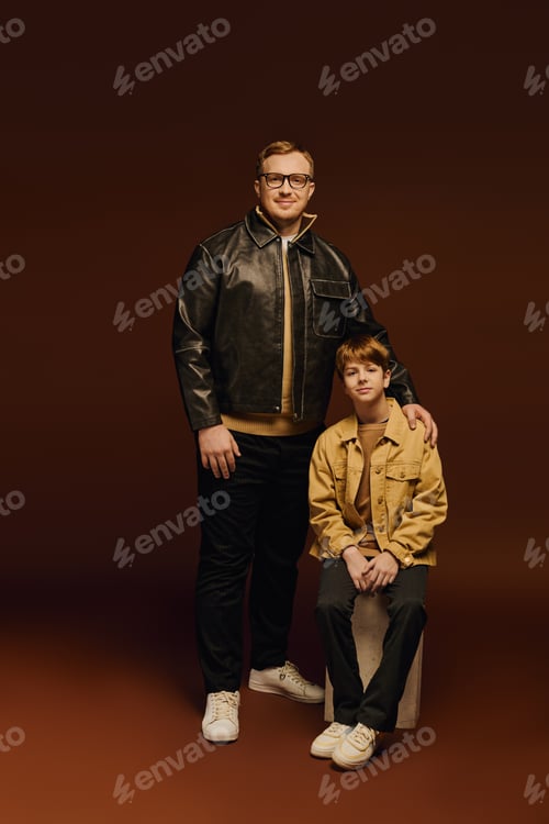 Preview: Father and son share a joyful moment in stylish outfits during a studio session