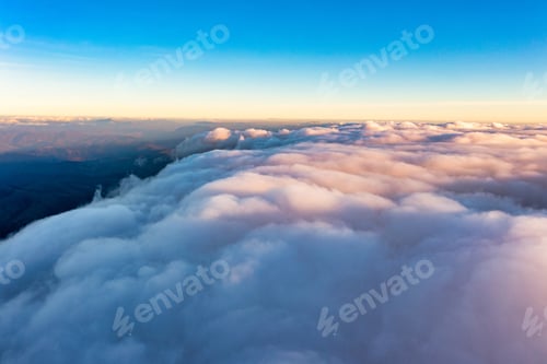 Preview: Thick layer of white clouds above mountains at sunrise