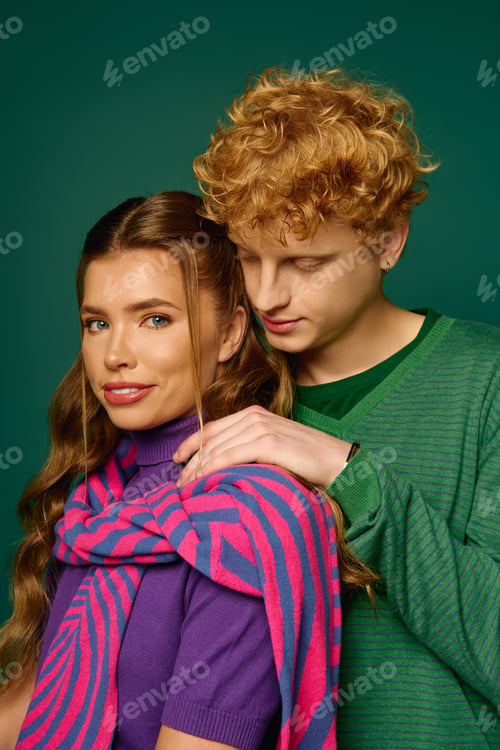 Preview: Young couple shares a moment of love and fashion in vibrant attire against a stylish backdrop