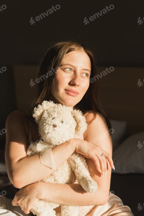 Preview: Portrait of girl is waking up in morning stretches in bed and sun shines from window. Happy young