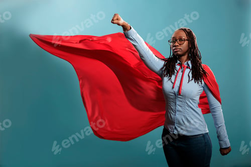 Preview: Strong justice defender with superpowers looking at camera with fist in air.