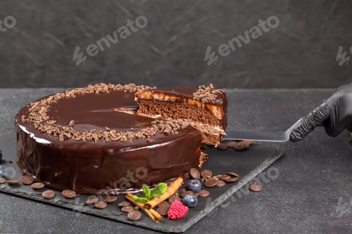 Visualização: Bolo de chocolate com um pedaço cortado e lâmina em fundo cinza, closeup