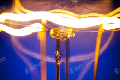 Preview: Close-up of burning light bulb with tungsten filament in center