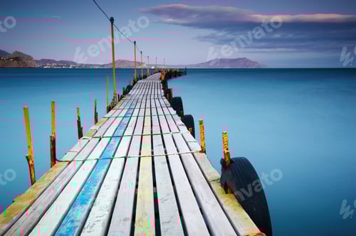 Preview: Wooden jetty on sea sunset and sky reflection water.
