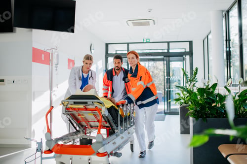 Preview: Young woman doctor taking care of patient from rescue ambulance.