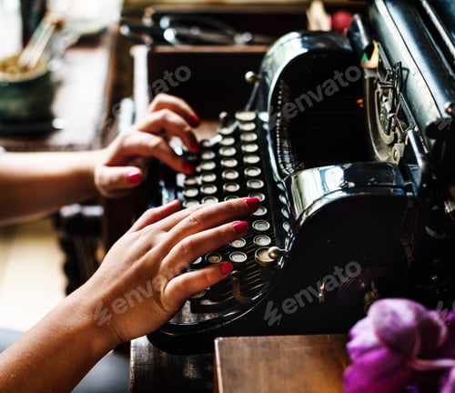 Preview: Woman typing vintage typewriter on wooden table