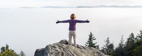 Preview: young tourist girl standing on top of rocks