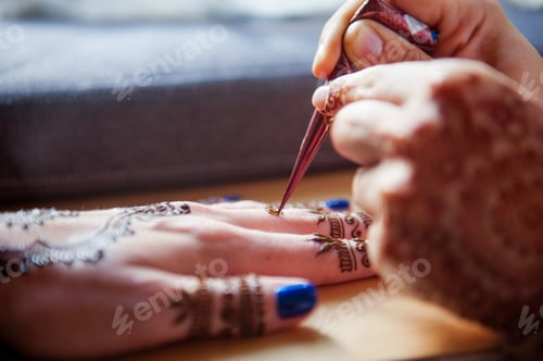 Preview: Drawing mehndi on the hand of a girl