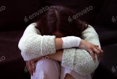 Preview: I need help. Shot of a young woman sitting on the floor and looking distressed.