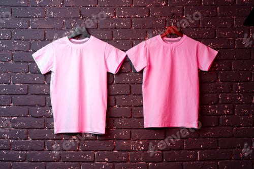 Preview: White t-shirt hanging on hanger against brick wall