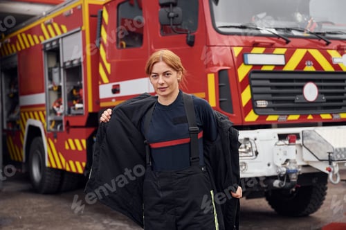 Preview: Taking off the protective clothes. Woman firefighter in uniform is at work in department