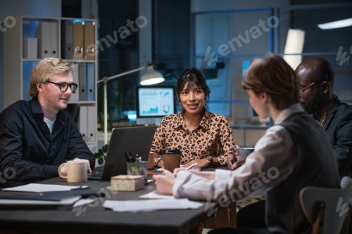 Preview: Business people sitting at meeting till late evening