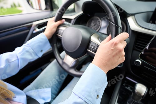 Preview: Blonde woman sits behind the wheel of a modern car