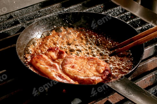 Preview: pork chops being fried in a pan with bubbling sauce on a stovetop - Tonkatsu sandwich preparation