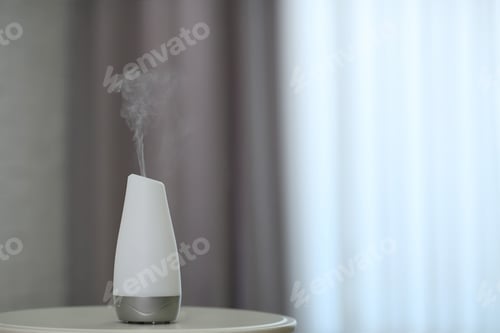 Preview: Aroma oil diffuser on table indoors. Space for text
