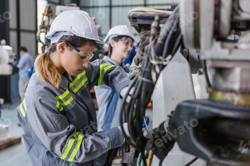 Preview: Engineers woman using wrench maintenance robotic arm. Female technician industrial checking robot ma