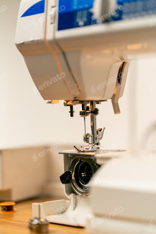 Preview: close-up in a sewing workshop a half-assembled sewing machine tongs and threads