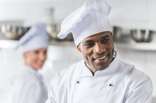 Preview: smiling multicultural chefs at restaurant kitchen