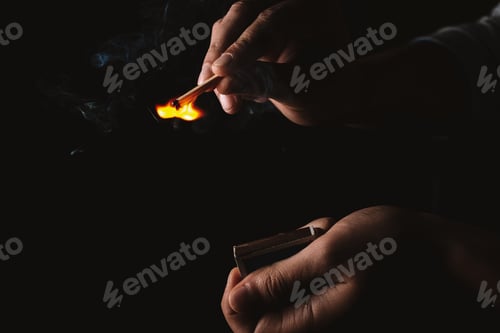 Preview: Burning match in the man's hand. Dangerous game with fire.