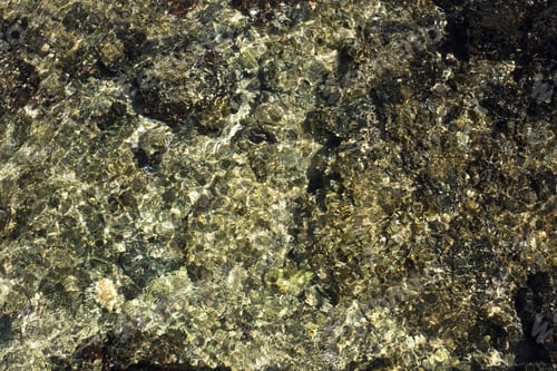 Preview: Abstract of the shallow water with light scatter from the pebbles in the crystal clear water.