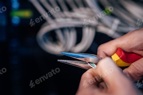 Preview: Close-up image of technician working on ethernet cable with long-nose pliers.