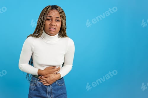 Preview: African woman touching her belly gesturing stomachache