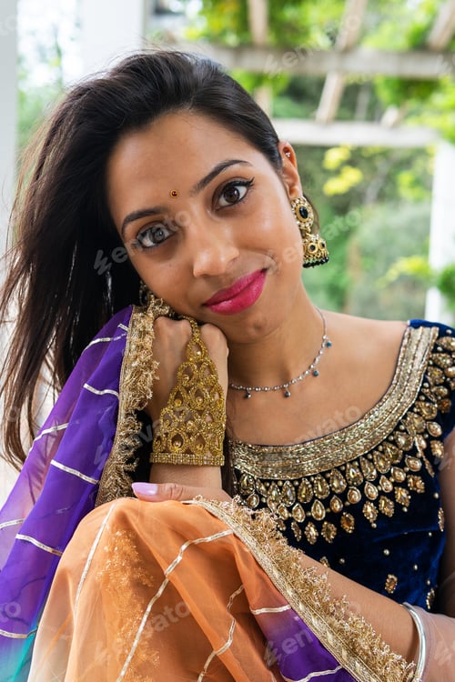 Preview: Stylish woman in traditional dress and jewelry at park
