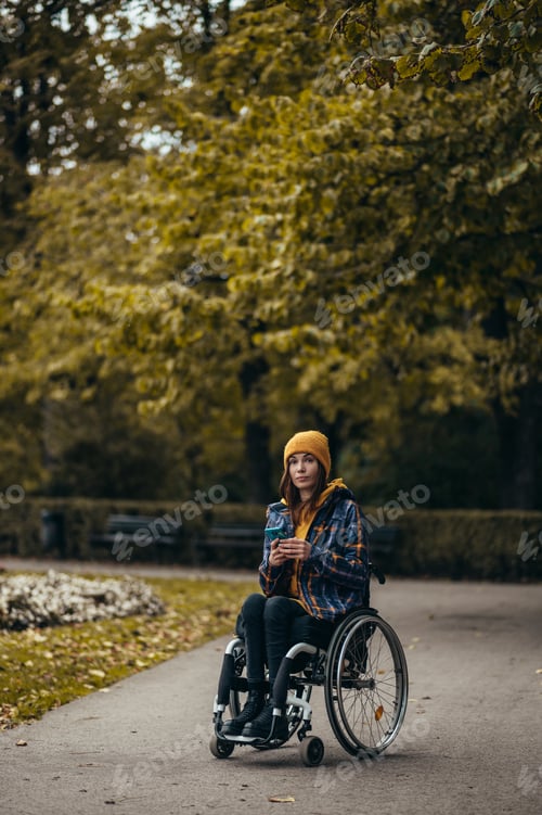 Preview: Woman with disability using a smartphone while out in the city park