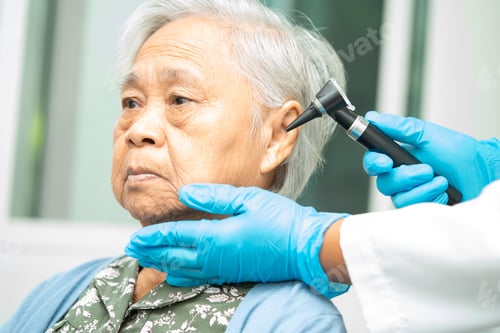 Preview: Audiologist or ENT doctor use otoscope checking ear of asian senior woman patient