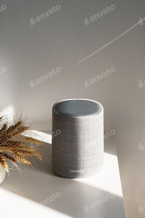 Preview: Modern gray speaker on table with soft shadows and light.
