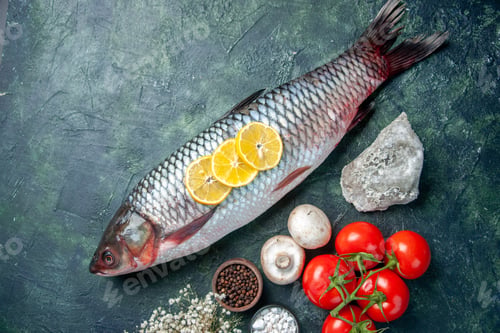 Preview: top view fresh raw fish with tomatoes and lemon on dark blue background shark seafood meal ocean