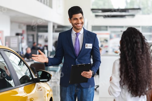Preview: Middle-eastern lady choosing new car, having conversation with sales manager