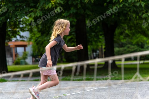 Preview: Young Girl Running Through an Obstacle Course in a Park on a Summer Day